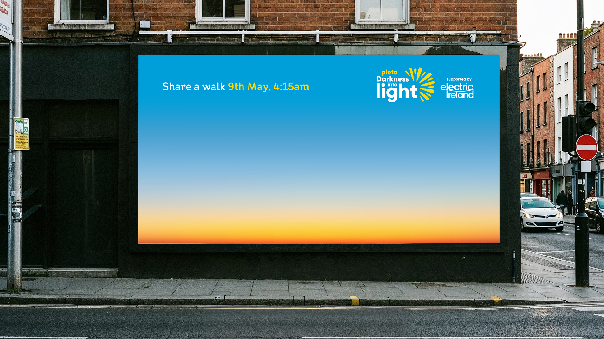 A billboard showing the Darkness Into Light sunrise image